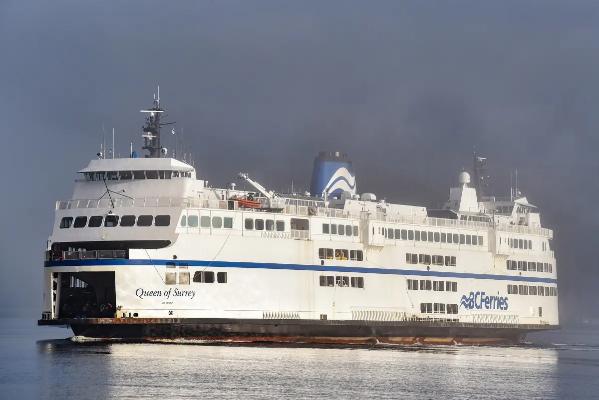 White BC Ferries vessel Queen of Surrey under a grey misty sky