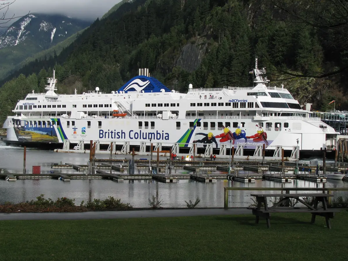 Large BC Ferries vessel docked at Horseshoe Bay with forested hills behind