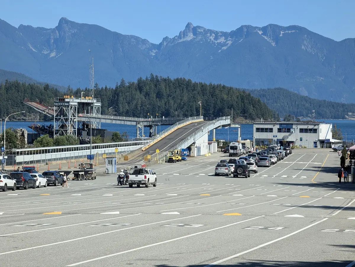 Langdale ferry terminal with parked vehicles and snowy mountains behind